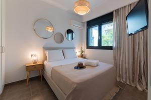 a bedroom with a bed with a mirror and a window at Prasonisi Villas in Kattavía