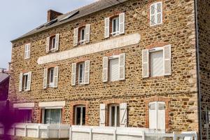 a brick building with a sign on the side of it at L'Odyssée - Studio cosy avec vue mer - Lumineux - Parking - Wifi in Pléneuf-Val-André