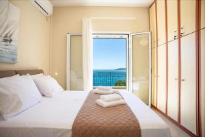 a bedroom with a large bed with a large window at Endless Seaview Villa in Argostoli