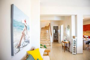 a living room with a staircase and a painting on the wall at Endless Seaview Villa in Argostoli