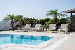 a group of lounge chairs next to a swimming pool at Prasonisi Villas in Kattavía