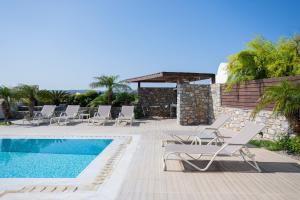 a villa with a swimming pool and lounge chairs at Prasonisi Villas in Kattavía