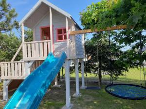a play house with a slide and a playground at Dom Geografów in Swornegacie 