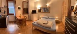 a bedroom with a bed and a kitchen with a table at Piccolo Rifugio di Foppolo in Foppolo
