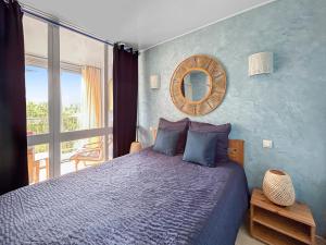 Un dormitorio con una cama con una pared azul. en T2, Calme & lumineux, au bout du jardin, la plage!, en La Grande-Motte