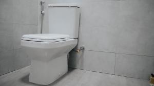 een badkamer met een wit toilet in een stal bij Roseney Home in Dar es Salaam