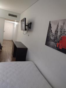 a bedroom with a bed and a picture of a red car on the wall at Depto torre Bayres Obelisco in Buenos Aires +3 photos
