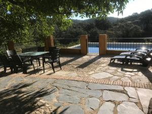a patio with a table and chairs and a fence at Puerto los Pinos in Cortegana