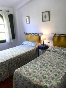 a hotel room with two beds and a lamp at Puerto los Pinos in Cortegana