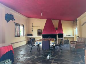 a room with a red ceiling with a table and a fireplace at Puerto los Pinos in Cortegana +4 photos