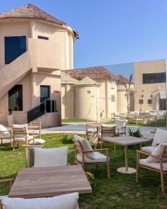 un grupo de mesas y sillas frente a un edificio en Dana Beach Resort, en Al Sharqiyah