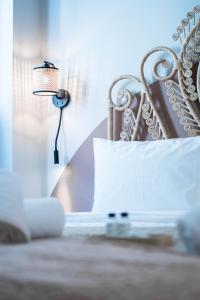 ein Bett mit einem weißen Kissen und einer Lampe in der Unterkunft Santa Rosa Apartments in Kalamata