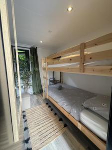 a wooden bunk bed in a room with a window at 6 Guest 3 BDR - Cozy Chalets VIP - Veluwe ijsvogel in Voorthuizen +24 photos