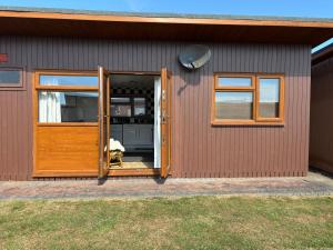 a dog is looking out the door of a house at g11 chalet in Mablethorpe