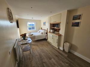 a bedroom with a bed and a table in a room at The Nest in Weymouth in Weymouth