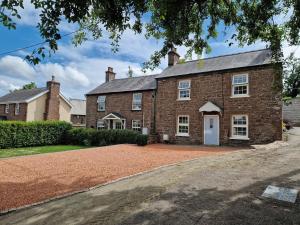 ein Backsteinhaus mit einer Einfahrt davor in der Unterkunft Pentwyn Cottage, Bwlch Brecon in Bwlch
