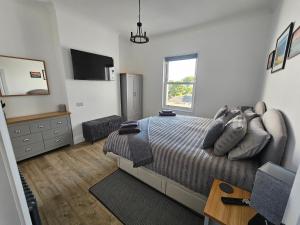a bedroom with a bed and a dresser and a window at The Nest in Weymouth in Weymouth