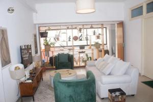 a living room with a white couch and chairs at Citycomfortluanda in Luanda