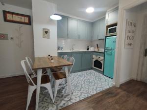 een keuken met een tafel en een blauwe koelkast bij CHECK-IN CASAS La casa de Teresa in Benasque