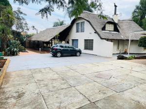 a car parked in front of a white house at Harmony Spaces in Kempton Park +5 photos