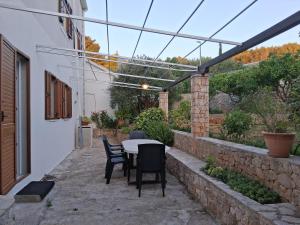 a patio with a table and chairs in a building at APARTMENTS JELENA SUPETAR - three apartments - a small house with a private yard - two-room apartment with a sea view - three-room apartment with garden and barbecue - free parking in Supetar +61 photos