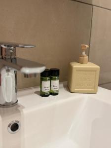 a bathroom sink with two bottles of essential oils and a soap dispenser at Anna's House in Kos