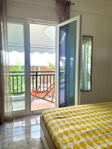 a bedroom with a bed and a balcony with sliding glass doors at Marias Apartment in Pefkohori +25 photos