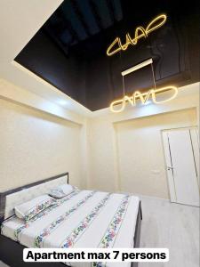 a room with a bed with a sign on the ceiling at Luxs Apartments in Tashkent with kitchen for 8-10persons ул Шоший64 in Tashkent