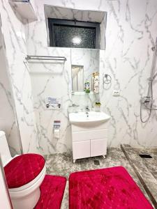 a bathroom with a toilet and a sink and a red rug at Luxs Apartments in Tashkent with kitchen for 8-10persons ул Шоший64 in Tashkent