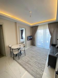a living room with a table and chairs and a couch at Rubin residence in Alanya