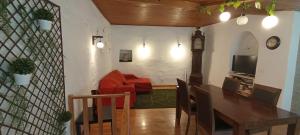 un soggiorno con tavolo, divano e orologio. di Casa do Rio a Coimbra