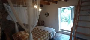 una camera da letto con un letto con una tenda davanti a una finestra di Casa do Rio a Coimbra Altre 37 foto
