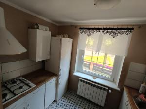 een keuken met een witte koelkast en een raam bij Dom Letniskowy in Wielen Zaobrzanski