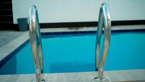 een zwembad met twee metalen rails ernaast bij Roseney Home in Dar es Salaam +7 foto's