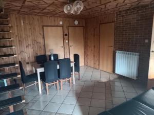 een eetkamer met een tafel en blauwe stoelen bij Dom Letniskowy in Wielen Zaobrzanski