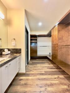 a kitchen with white cabinets and a wooden floor at Mar y Sol 15th Floor 3BR 2 BA Condo with pool in Rosarito