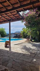 a patio with a tree and a swimming pool at Rancho do Veio - Jarinu in Jarinu