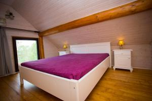 a bedroom with a large white bed with a purple blanket at Wolf's House in Gura Rîului