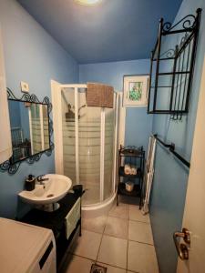a blue bathroom with a sink and a shower at TóPart Vendégház Velence in Velence +9 photos
