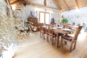 a dining room with a wooden table and chairs at TheGreenShelter in Čepovan