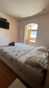 a bedroom with a bed and a window at Casa Maré in Búzios