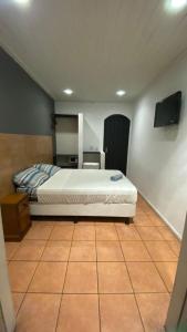une chambre avec un lit et une télévision à écran plat dans l'établissement Casa Maré, à Búzios