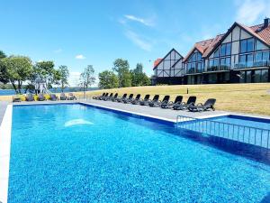 a swimming pool with chairs and a house at Ostoja Orli Dziób C1 in Kal