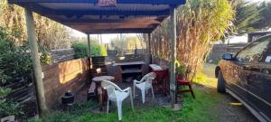 a pergola with chairs and a grill in a yard at Ema Juan in Navidad