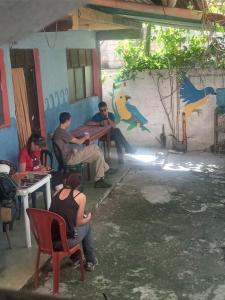 een groep mensen die rond een tafel in een kamer zitten bij Hostal Zope in Cataltzul