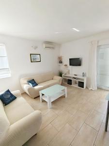 a living room with a couch and a table at Apartments Višnja in Pag