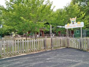 una valla con un cartel delante de un parque infantil en Camping rivages des Landes, en Aureilhan