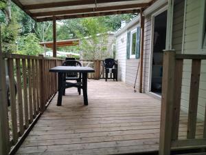 a wooden deck with a table and chairs on it at Camping rivages des Landes in Aureilhan