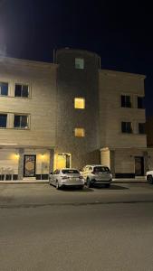 two cars parked in front of a building at night at استديو جديد in Hail