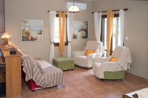 a living room with chairs and a table at Duchess Eva's Seafront Guesthouse in Chorefto